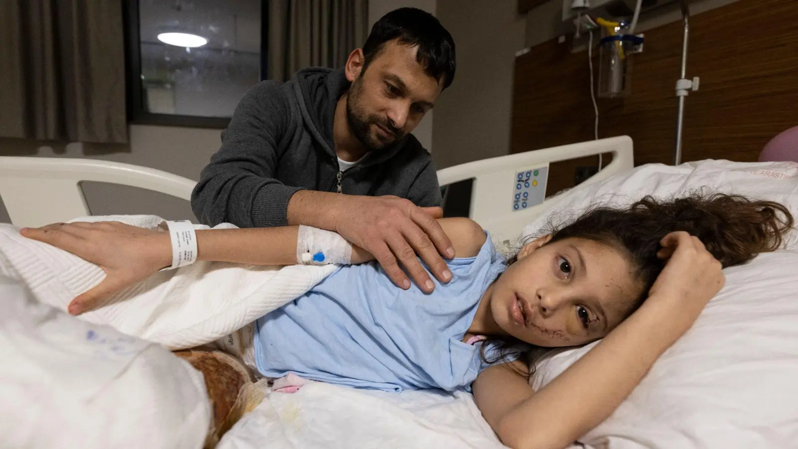Zärtlich streicht Serkan Agri seiner Tochter Saadet im Krankenhaus von Adana über den Arm. (Foto: Boris Roessler/dpa)