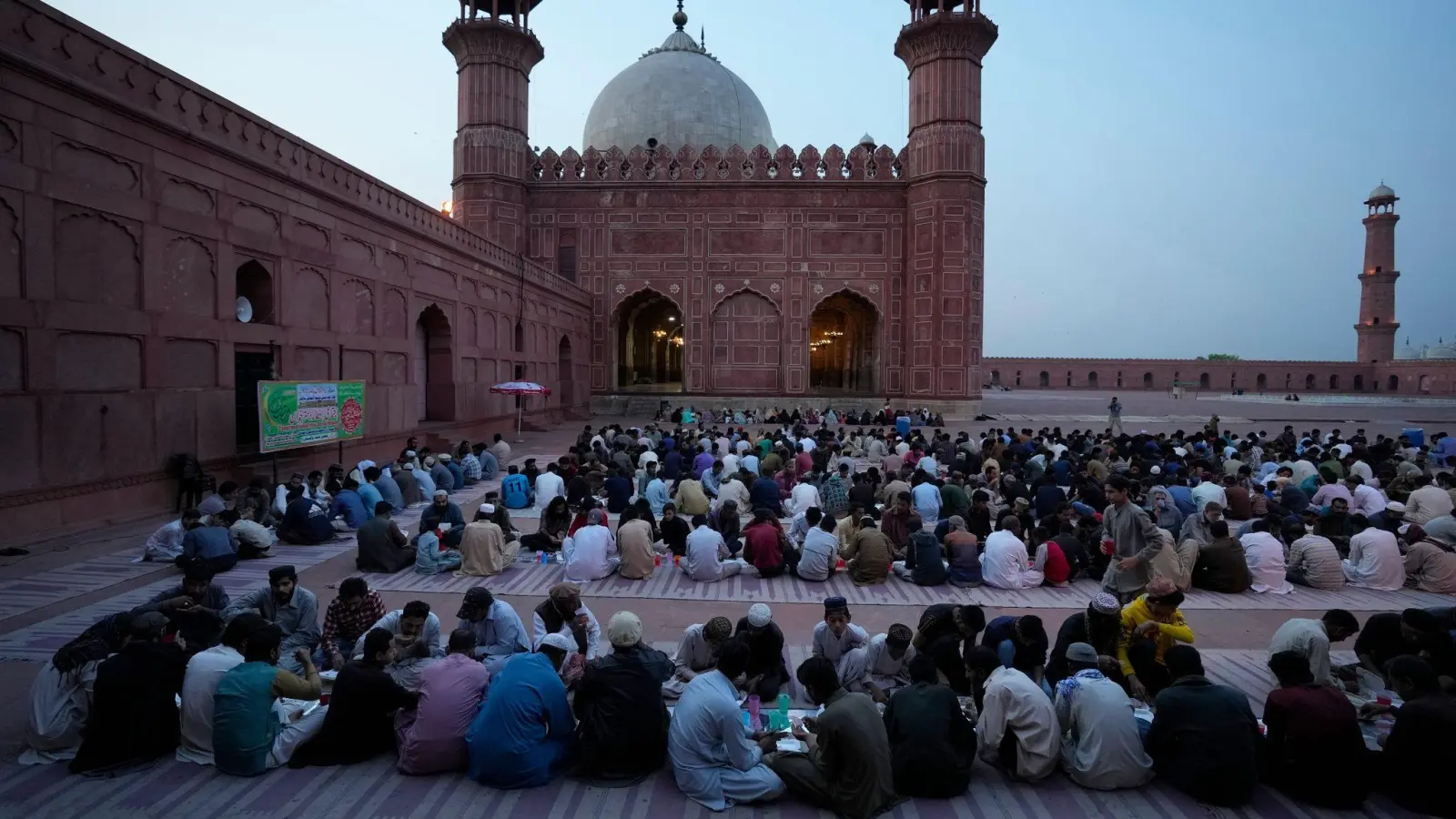 Menschen brechen ihr Fasten während des heiligen muslimischen Fastenmonats Ramadan in der Badshahi-Moschee in Lahore. Muslime in aller Welt verzichten während des Ramadan von Sonnenaufgang bis Sonnenuntergang auf Essen, Trinken und Rauchen. (Foto: K.M. Chaudary/AP/dpa)