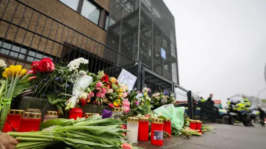 Blumen und Kerzen erinnern vor dem Eingangsbereich des Gemeindehauses in Hamburg an die Opfer der Amoktat. (Foto: Christian Charisius/dpa)