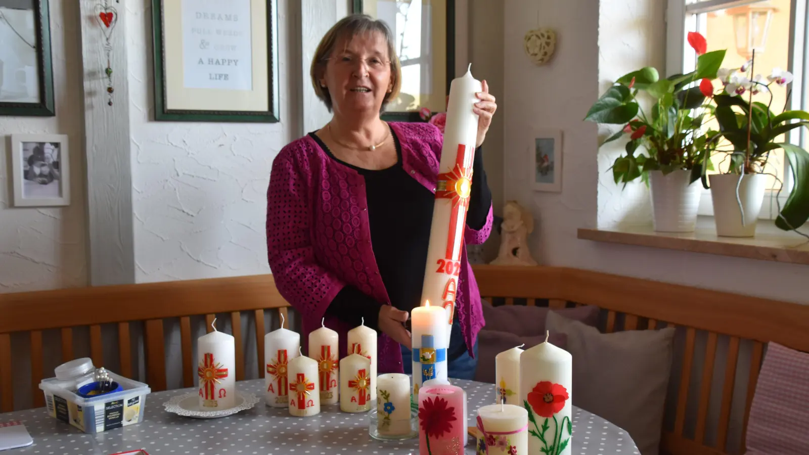 Anna Schwab gestaltet mit Begeisterung und Hingabe Kerzen, gerne auch Osterkerzen. Auf dem Foto hält sie jene für die evangelische Kirche in Lonnerstadt in Händen. (Foto: Andreas Reum)