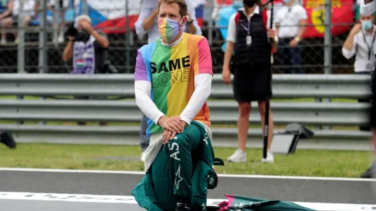 Aston-Martin-Pilot Sebastian Vettel kniet vor einem Rennen zur Unterstützung der Black-Lives-Matter-Bewegung nieder und trägt ein T-Shirt in Regenbogenfarben. (Foto: Florion Goga/Pool Reuters/AP/dpa)