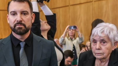Klägerin Rita M. kommt mit ihrem Anwalt Daniel Kuhlmann (links) und dem zweiten Kläger Joachim Alfred Wagner (rechts) in den Gerichtssaal. (Foto: Oliver Berg/dpa)