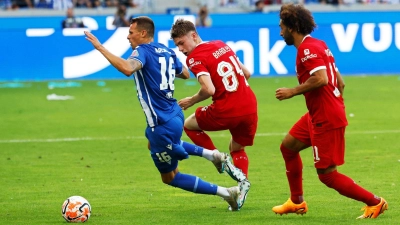 Karlsruhes Philip Heise (l-r) in Aktion gegen Liverpools Conor Bradley und Mohamed Salah. (Foto: Philipp von Ditfurth/dpa)