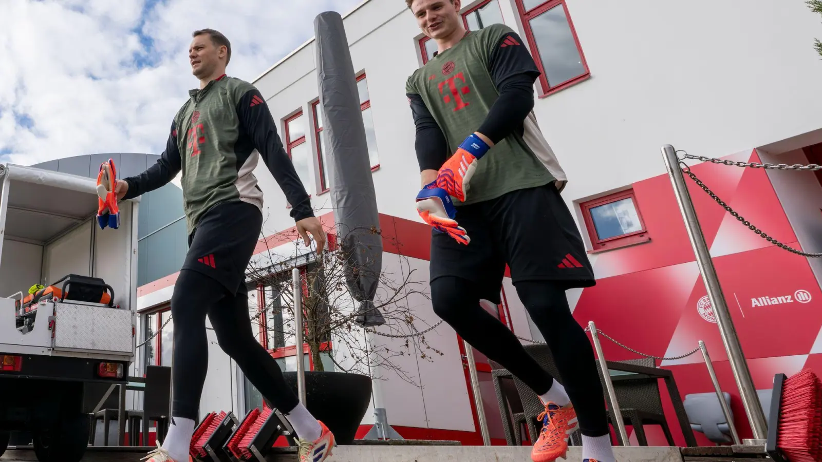Torwart Manuel Neuer (l) und Ersatzkeeper Jonas Urbig auf dem Weg auf den Trainingsplatz. (Foto: Peter Kneffel/dpa)