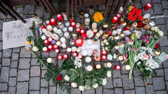 Auf dem Platz vor dem Blumengeschäft sind Blumen und Kerzen niedergelegt. (Foto: Daniel Vogl/dpa/Archivbild)