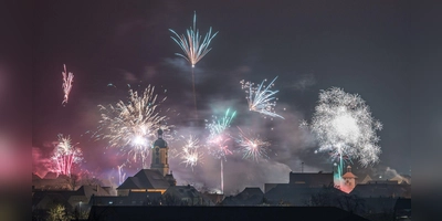 Feuerwerk über der Stadt Scheinfeld mit Blick auf die Stadtpfarrkirche Mariä Himmelfahrt und rechts den Torbogen. (Foto: Mirko Fryska)
