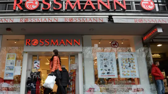 Eine Frau geht an einer Rossmann-Filiale vorbei. (Foto: Andreas Gebert/dpa/Archivbild)