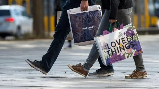 Ein Mann und eine Frau mit Einkaufstüten in einer deutschen Innenstadt. In der Eurozone hat sich die Verbraucherstimmung noch einmal verbessert. (Foto: Monika Skolimowska/ZB/dpa)