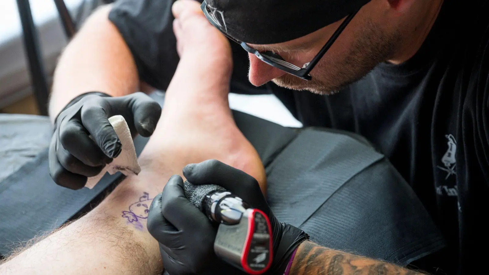 Tätowierer Tobias Hilfenhaus tätowiert in seinem mobilen Tattoo-Studio eine Karotte. (Foto: Daniel Vogl/dpa)
