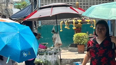 Menschen schützen sich in Bangkok mit Schirmen vor der extremen Hitze und vor der Sonne. Nicht nur in Thailand, sondern auch auf den Philippinen leiden die Menschen derzeit unter den hohen Temperaturen. (Foto: Carola Frentzen/dpa)