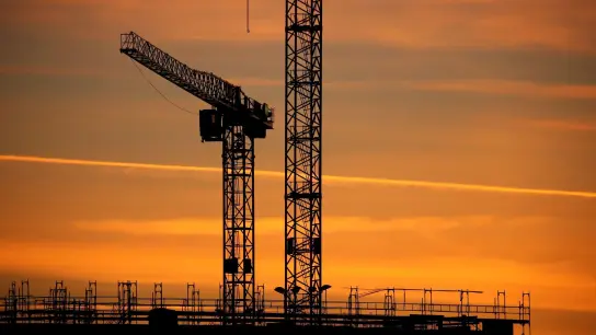 Baukräne einer Großbaustelle im Sonnenaufgang: Das Geschäftsklima verbesserte sich in allen betrachteten Wirtschaftsbereichen. (Foto: Karl-Josef Hildenbrand/dpa/dpa)