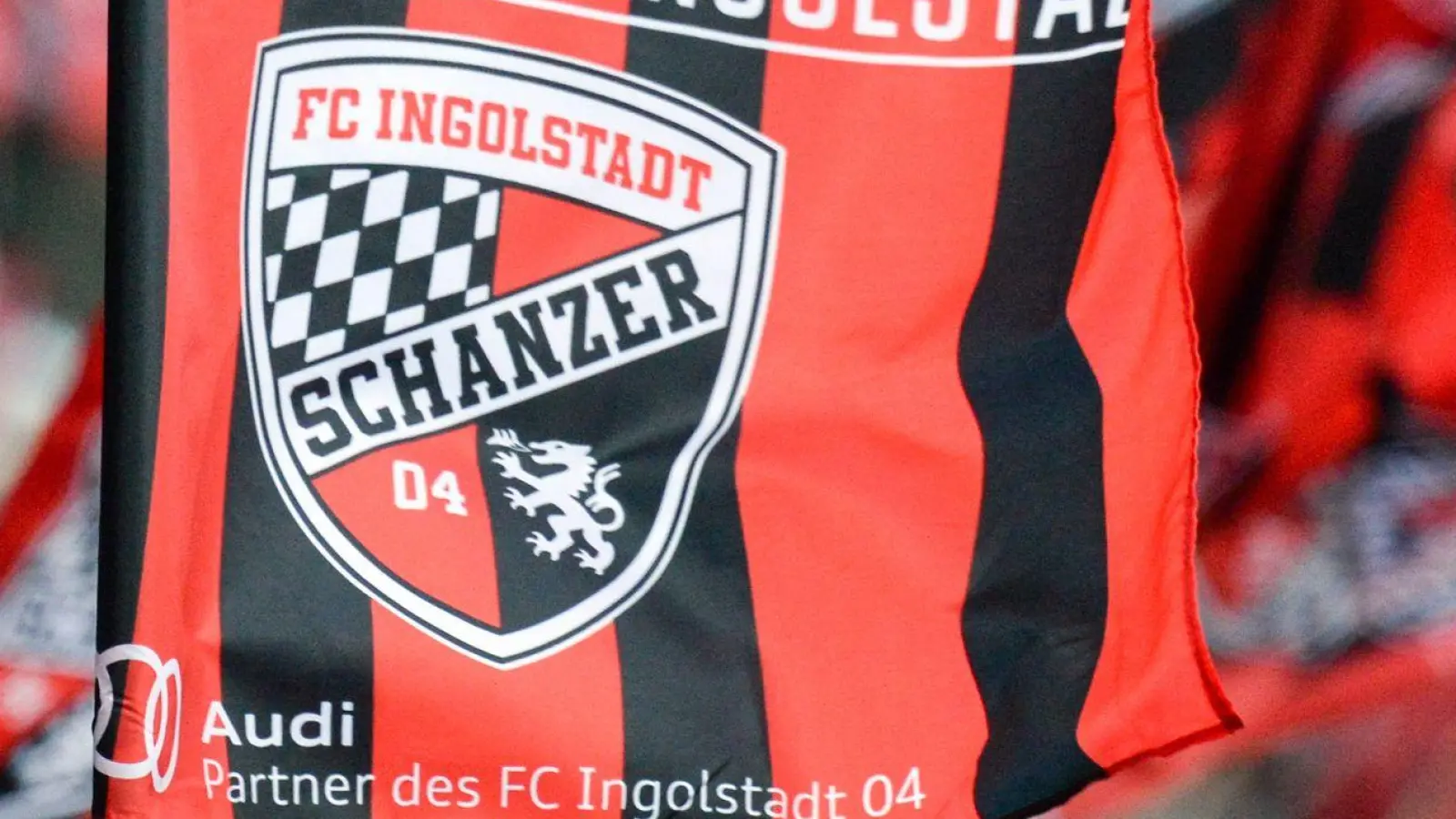 Fans von Ingolstadt winken mit Fahnen im Stadion. (Foto: Armin Weigel/dpa)