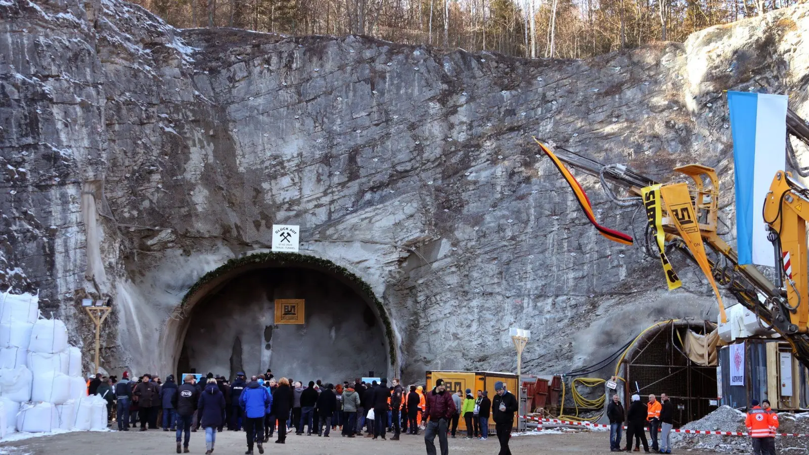 Arbeiter und Gäste stehen nach dem offiziellen Tunnelanschlag vor dem zukünftigen Nordportal des Kramertunnels. (Foto: Stephan Jansen/dpa/Archivbild)
