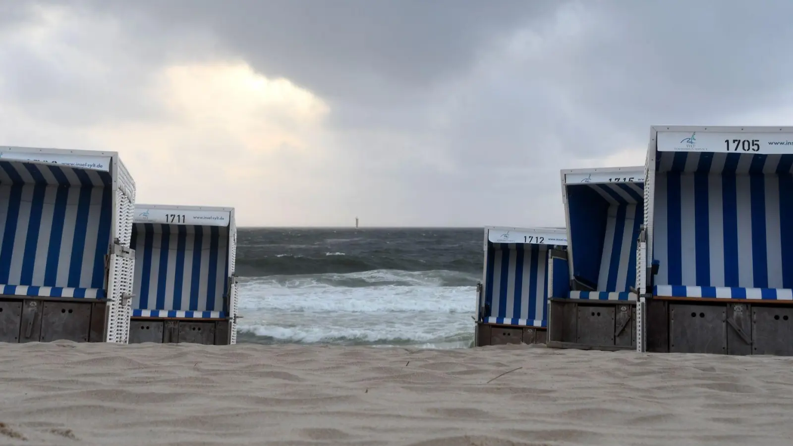 Leere Strandkörbe vor aufgepeitschter Nordsee: Am Strand vor Westerland zeigt sich die Nordseeinsel Sylt von seiner stürmischen Seite. (Foto: Lea Sarah Albert/dpa)