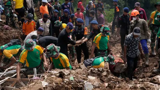 Rettungskräfte suchen nach den Opfern eines durch das Erdbeben ausgelösten Erdrutsches. (Foto: Tatan Syuflana/AP/dpa)