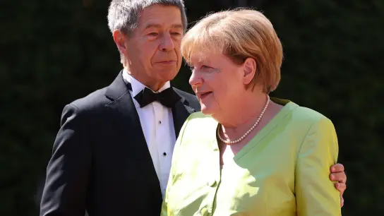 Angela Merkel (im Bild mit Ehemann Joachim Sauer) bekommt monatlich Altersbezüge von 15.000 Euro. (Foto: Daniel Karmann/dpa)