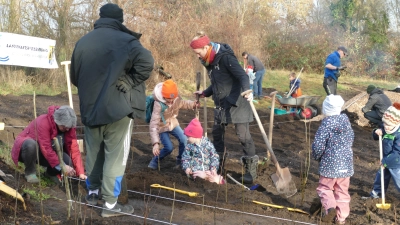 Bei einer Pflanzaktion wurden die ersten 1200 Bäumchen für einen Tiny Forest, als natürliche Grenze für die dort geplante Naturgruppe des Kindergartens Arche Noah, gesteckt. (Foto: Helmut Meixner)