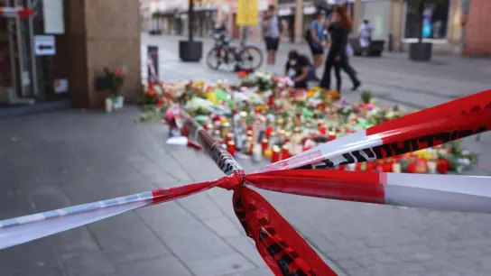 Blumen und Kerzen vor dem abgesperrten Kaufhaus, wo ein Mann Menschen mit einem Messer attackiert hatte. (Foto: Karl-Josef Hildenbrand/dpa)