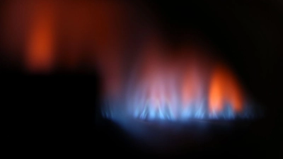 Eine Gasflamme brennt hinter dem Sichtfenster eines Gas-Durchlauferhitzers. (Foto: Karl-Josef Hildenbrand/dpa)