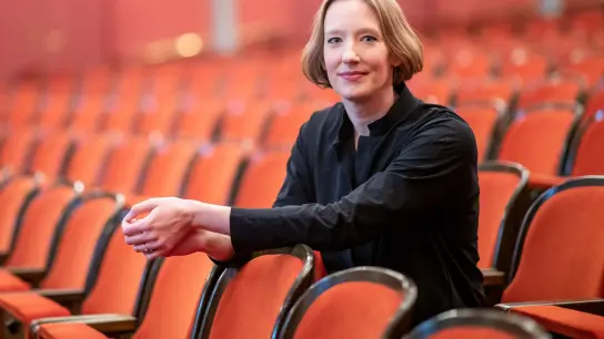 Die Star-Dirigentin Joana Mallwitz sitzt im Opernhaus des Staatstheaters Nürnberg im Zuschauerbereich. (Foto: Daniel Karmann/dpa/Archivbild)