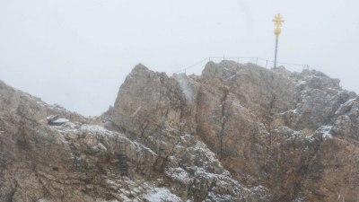 Nebelwolken umhüllen bei Schneetreiben auf der Zugspitze die Aussichtsplattform mit dem Gipfelkreuz (Archivbild). Aus <br>mehreren Bergsteigergruppen wurden Notrufe abgesetzt, nachdem sie aufgrund von Witterung und Neuschnee auf etwa 2500 Metern Höhe nicht mehr weiterkamen. (Foto: Peter Kneffel/dpa)