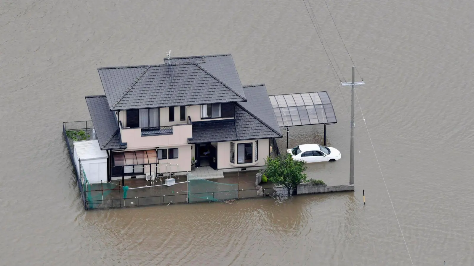 Ein vom Hochwasser umschlossenes Haus in Toyokawa. (Foto: Uncredited/Kyodo News/AP/dpa)