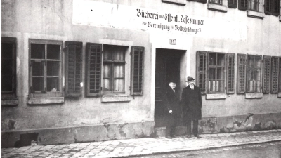 Der erste Leiter der Bücherei, Georg Schumann (rechts) steht mit einem Helfer namens Förster im Jahre 1925 vor dem ersten Domizil der Bibliothek in der Endresstraße 14. (Foto: Stadt Ansbach)