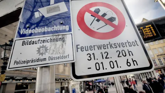 Hinweisschilder auf Videoüberwachung und Böllerverbot hängen am Zugang zur Altstadt in Düsseldorf. (Foto: Martin Gerten/dpa)