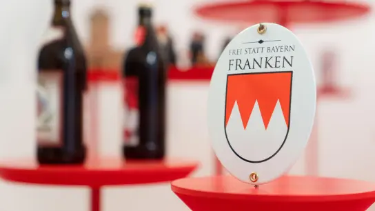 Bierflaschen und ein Schild mit der Aufschrift „Frei statt Bayern - Franken“. (Foto: Nicolas Armer/dpa)
