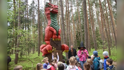 Der Drache und seine Schöpfer: Autorin Miriam Mendl-Möhring (mit schwarzem Hexenhut) und der Künstler Reinhard Bader. Die Kinder hatten ihre Freude daran. (Foto: Anita Dlugoß)