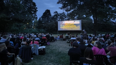 Gut gefüllt war das Wörnitzstrandbad, als dort zum Beginn der Ferien auf der Leinwand „Glennkill” gezeigt wurde. Während die einen Besuchenden auf Stühlen Platz nahmen, breiteten andere ihre Decken aus. (Foto: Julia Bergmeister)