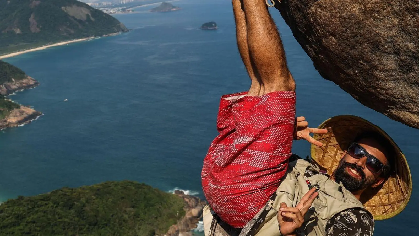 Ein Mann hängt für ein Bild an dem Felsen „Pedra do Telegrafo“ bei Rio de Janeiro. (Foto: Aline Massuca/)