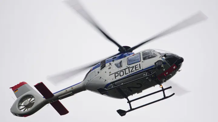 Ein Polizeihubschrauber fliegt bei einem Sucheinsatz über eine Stadt. (Foto: Robert Michael/dpa-Zentralbild/ZB/Symbolbild)