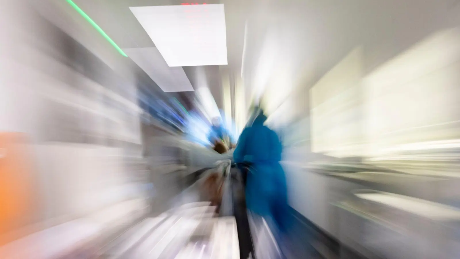 Pflegekräfte transportieren einen Patienten auf einem Gang einer Intensivstation (Zoomeffekt durch lange Belichtungszeit). (Foto: Frank Molter/dpa/Archivbild)