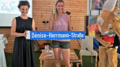 Bei einem Besuch in Bockau überreichte Herriedens Bürgermeisterin Dorina Jechnerer (links) an Denise Herrmann-Wick ein Schild mit der Aufschrift „Denise-Herrmann-Straße“. (Foto: Gemeinde Bockau)