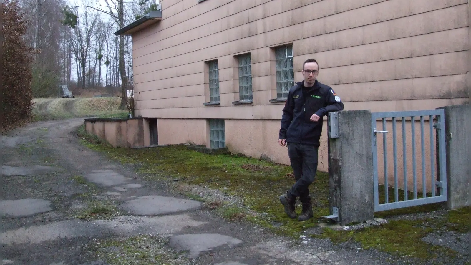Bröckelnde Wegeoberflächen und eine verwitterte Fassade: Das Domizil des THW-Ortsverbandes Feuchtwangen in Banzenweiler ist mittlerweile völlig veraltet. Für den Ortsbeauftragten Florian Stöckert ist ein Neubau daher unausweichlich.  (Foto: Jasmin Kiendl)