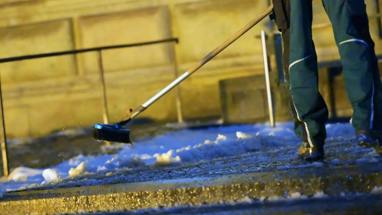 Ein Mann räumt Schnee vor der Alten Pinakothek in München. In der Nacht soll es wieder kälter werden, mit Schneefall bis in die Niederungen.  (Foto: Malin Wunderlich/dpa)