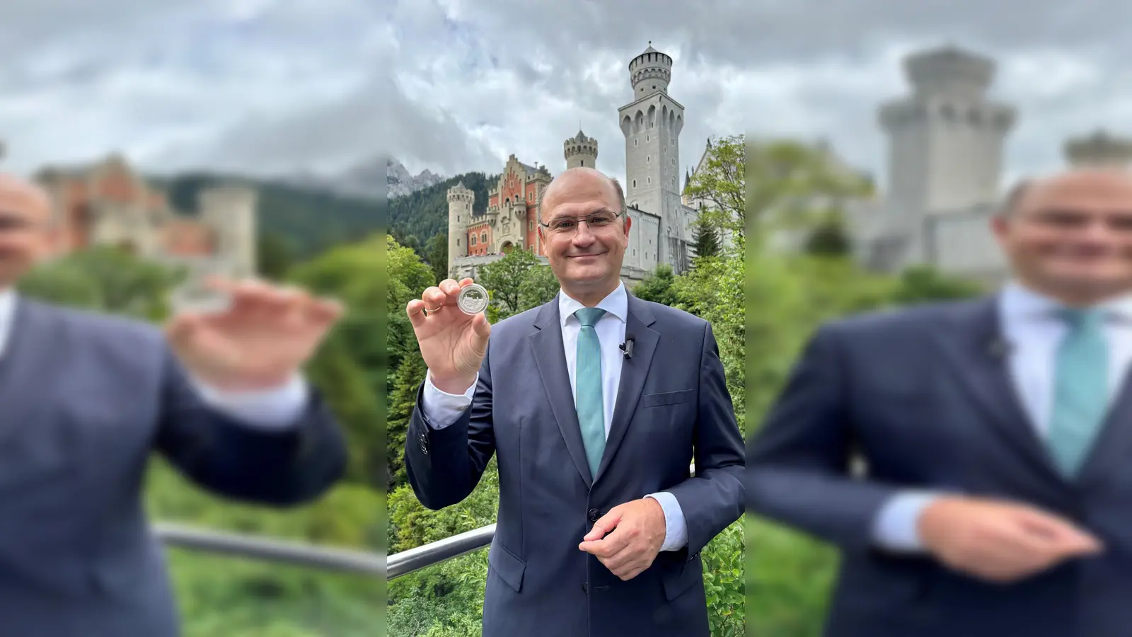 Finanzminister Albert Füracker (CSU)&nbsp;mit dem „Bayern Thaler“ in der Hand vor Schloss Neuschwanstein. (Foto: -/Bayerisches Finanzministerium/dpa)