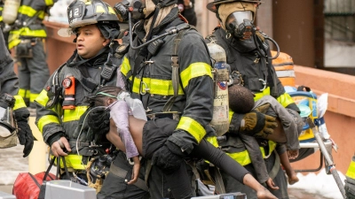 Feuerwehrleute tragen Kinder aus einem Wohnhaus in der Bronx. Bei dem Feuer sind nach Angaben des Bürgermeisters Adams 19 Menschen getötet worden. (Foto: Theodore Parisienne/New York Daily News/TNS via ZUMA Press Wire/dpa)