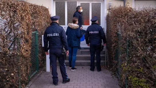 Die Polizei steht vor einem Haus eines Verdächtigen in München. (Foto: Peter Kneffel/dpa)