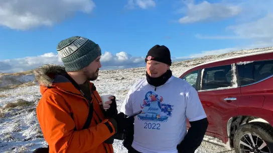 „Penguin News“-Reporter Nick Roberts (l) im Interview mit Marcus Morrison, Organisator des Winterschwimmens auf den Falklandinseln. (Foto: Benedikt von Imhoff/dpa)