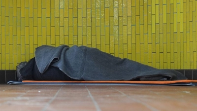 Ein Obdachloser liegt in seinem Schlafsack in einer U-Bahnstation in der Hamburger Innenstadt. 17,7 Millionen Menschen waren 2023 in Deutschland von Armut oder Ausgrenzung bedroht. (Foto: Marcus Brandt/dpa)