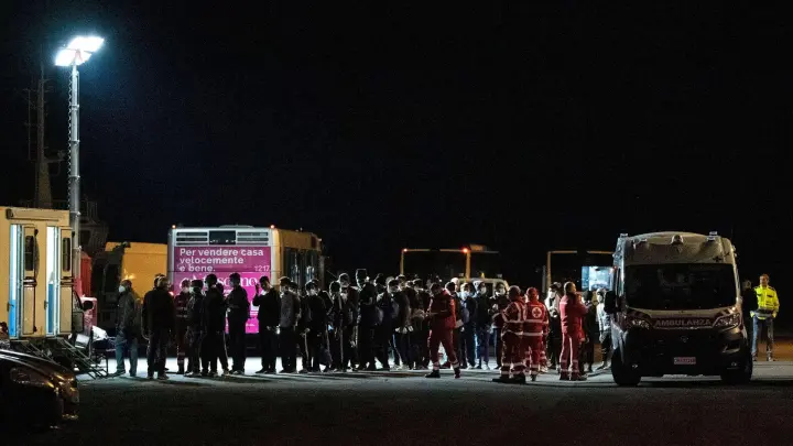 Migranten verlassen das unter norwegischer Flagge fahrende Rettungsschiff „Geo Barents“, nachdem sie von den italienischen Behörden im Hafen von Catania auf Sizilien an Land gelassen wurden. (Foto: Salvatore Cavalli/AP/dpa)
