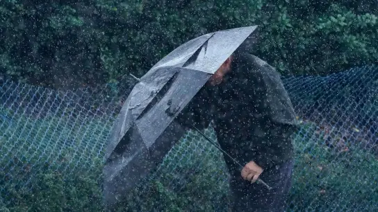 Ein Mann schützt sich in San Francisco vor Wind und Regen. (Foto: Jeff Chiu/AP/dpa)