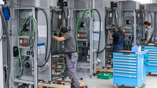 Mitarbeiter verdrahten im Leipziger Siemens-Werk Ladesysteme für Elektroautos. Bei der Angleichung der Arbeitszeiten ans West-Niveau sind die Betriebe der Metall- und Elektroindustrie in Ostdeutschland aus Sicht der IG Metall auf einem guten Weg. (Foto: Jan Woitas/dpa)
