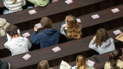 Studenten nehmen an der Einführungsveranstaltung im Audimax der Ludwig-Maximilians-Universität teil. (Foto: Peter Kneffel/dpa)