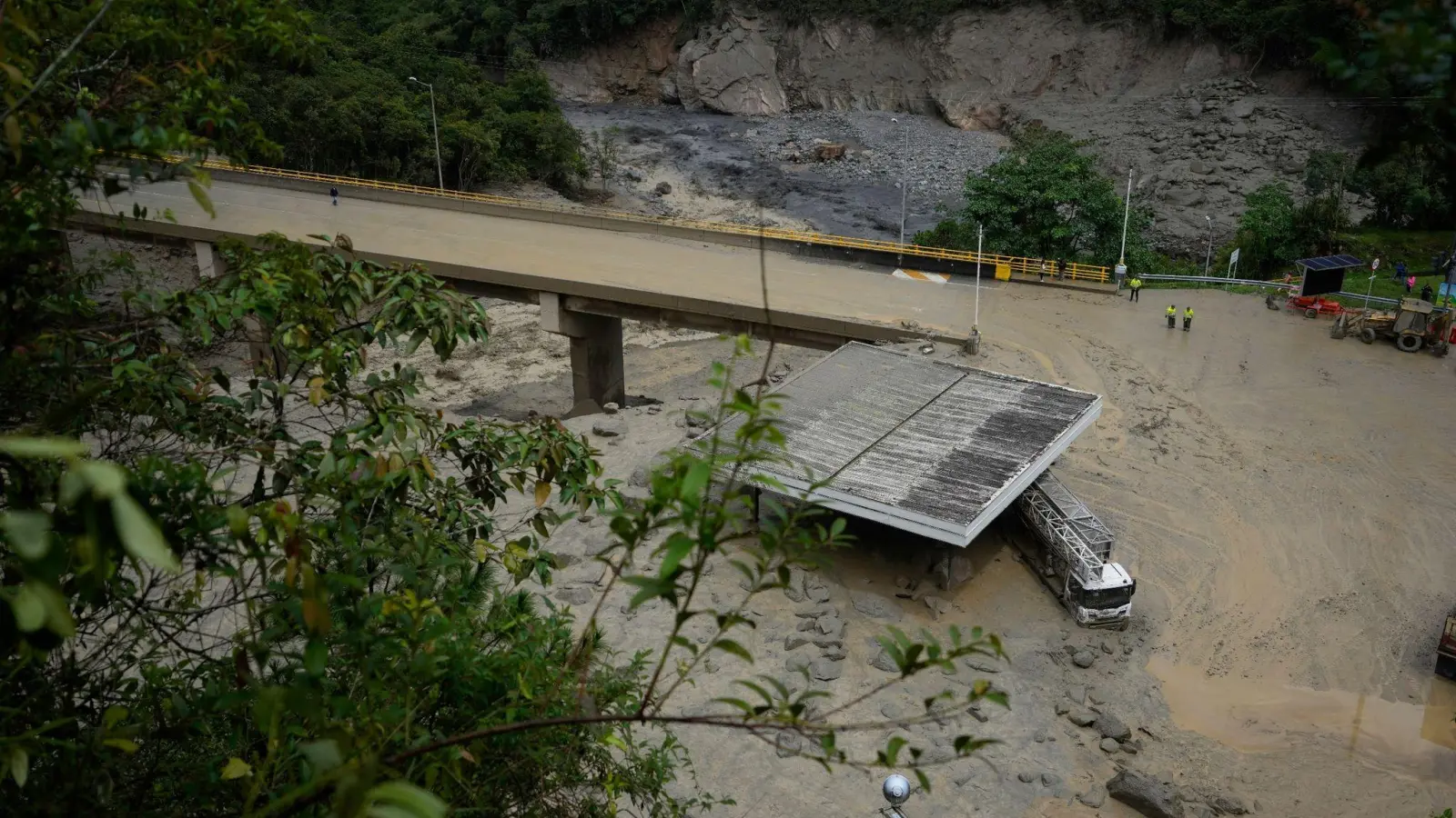 Ein schlammbedeckter Lastwagen steht nach einem Erdrutsch unter einer Brücke. (Foto: Fernando Vergara/AP/dpa)