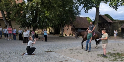 Die Lore kniet vor dem Feldherren auf dem Pferd nieder. Im Spitalhof in Dinkelsbühl wurde am Montagabend die Stadtübergabe geprobt. (Foto: Friedrich Zinnecker)