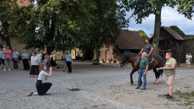 Die Lore kniet vor dem Feldherren auf dem Pferd nieder. Im Spitalhof in Dinkelsbühl wurde am Montagabend die Stadtübergabe geprobt. (Foto: Friedrich Zinnecker)