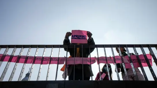 Eine Person hält ein Blatt mit dem Schriftzug „Ich stimme zu“ hoch. Einen Monat vor der Abstimmung über eine neue Verfassung in Chile ist der Entwurf zum Bestseller geworden. (Foto: Esteban Felix/AP/dpa)